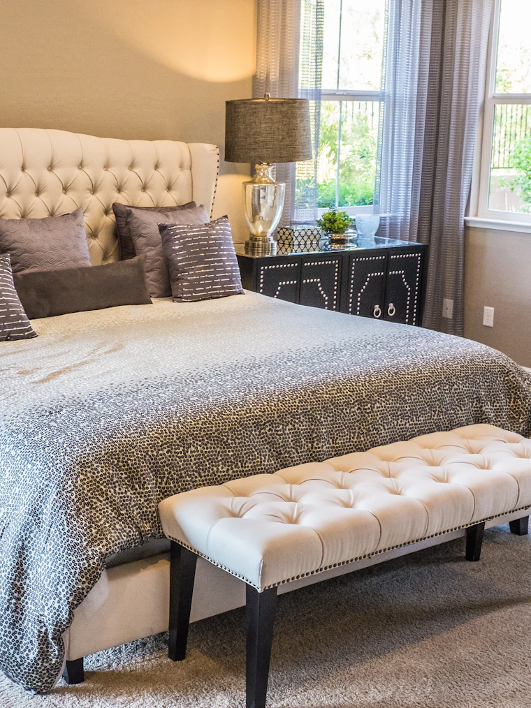 Bedroom interior design with a tufted headboard and warm lighting